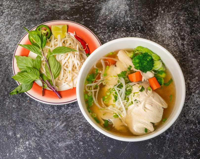Chicken pho with broccoli, carrots, and a side of basil, bean sprouts, lime, and chili.